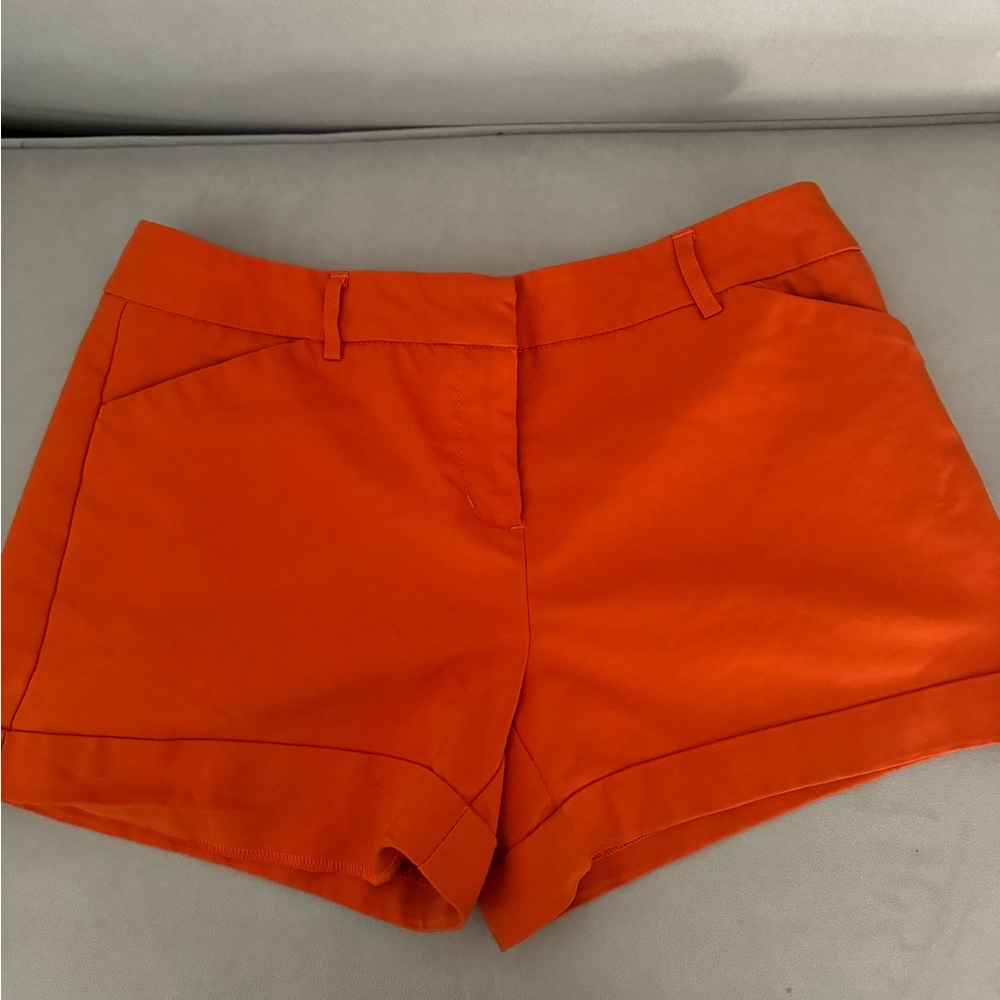 Versona orange shorts. Pockets and belt loops.